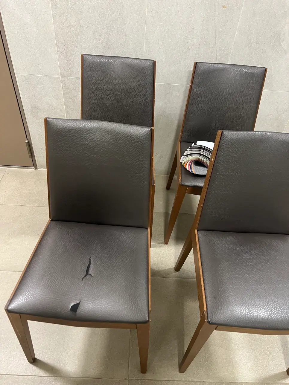 식탁의자 천갈이 시공 전: 표면 가죽이 갈라지고 벗겨진 낡은 브라운 인조가죽 의자 상태